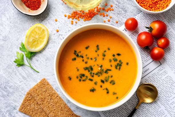 Top view of winter spicy lentil cream soup on light blue background